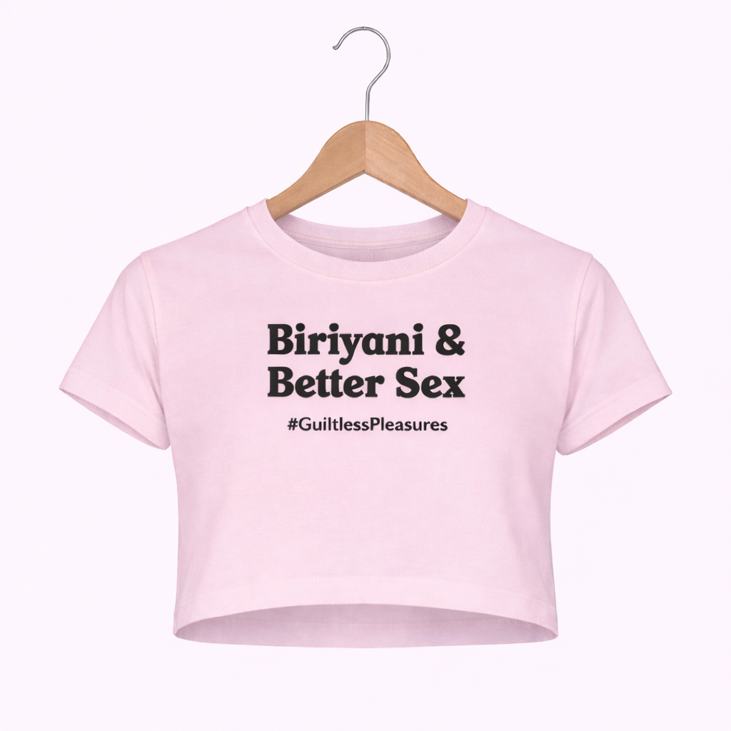 Pink crop top with text on a hanger against a white background