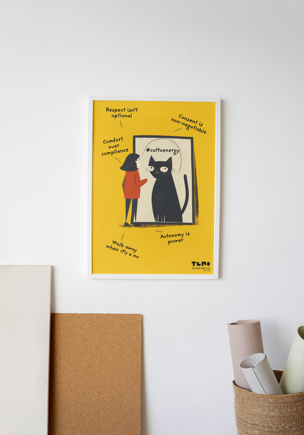 Poster with a black cat illustration on a yellow background, hanging on a white wall.
