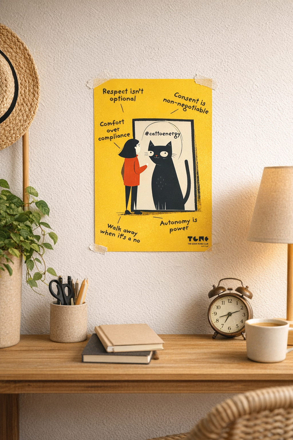 Poster with a black cat illustration on a yellow background, placed on a shelf with decor items.