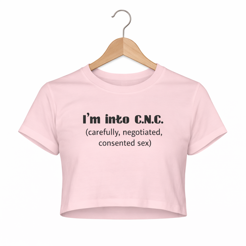 Pink crop top with text on a hanger against a white background