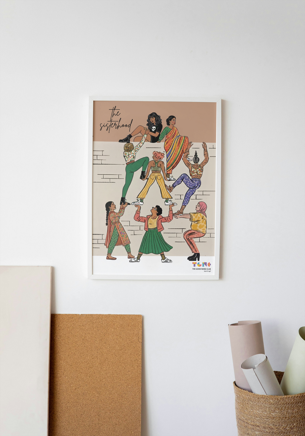 Framed artwork of a group of people in a circle on a white wall.