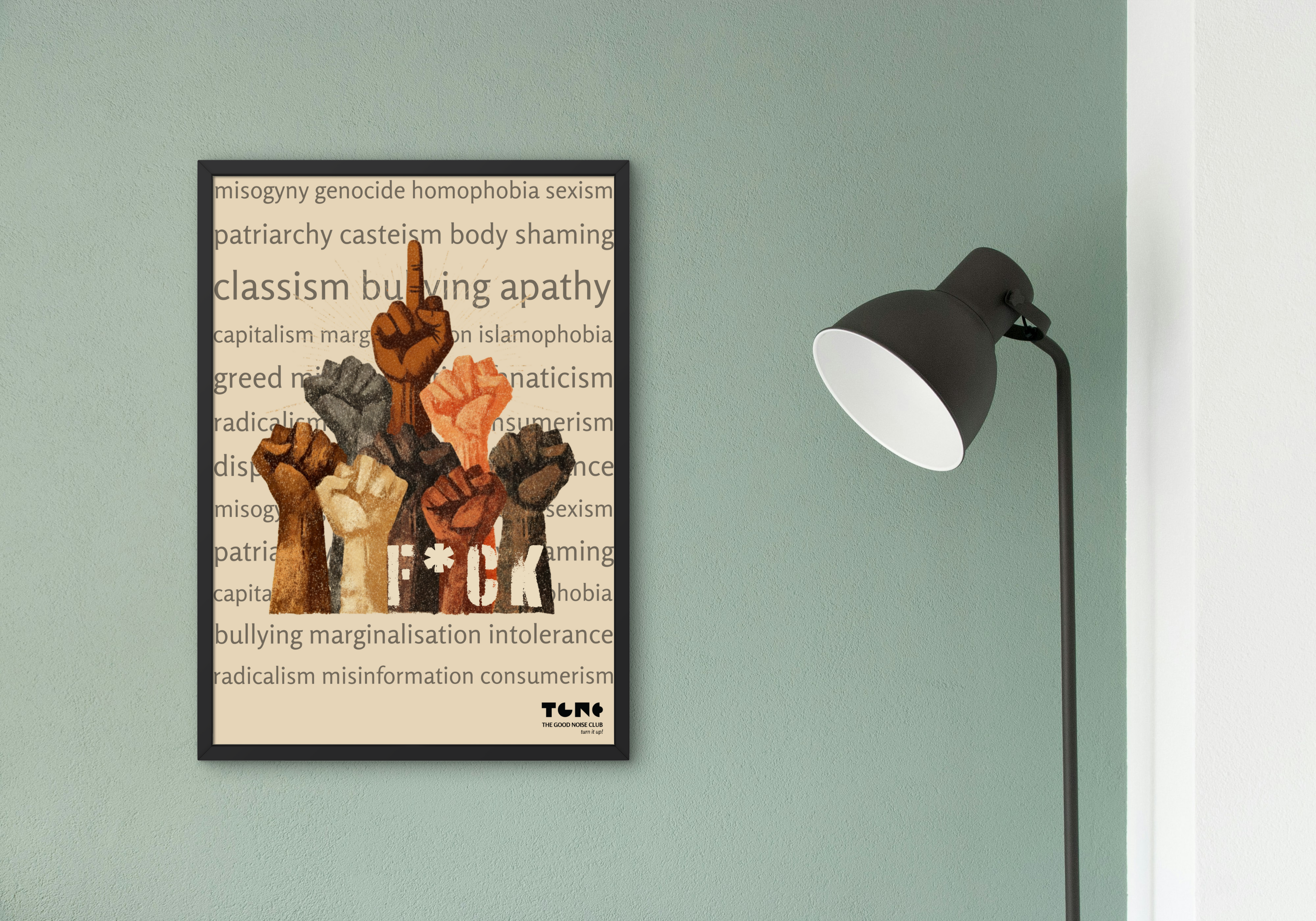 Framed artwork with raised fists on a wall next to a lamp.