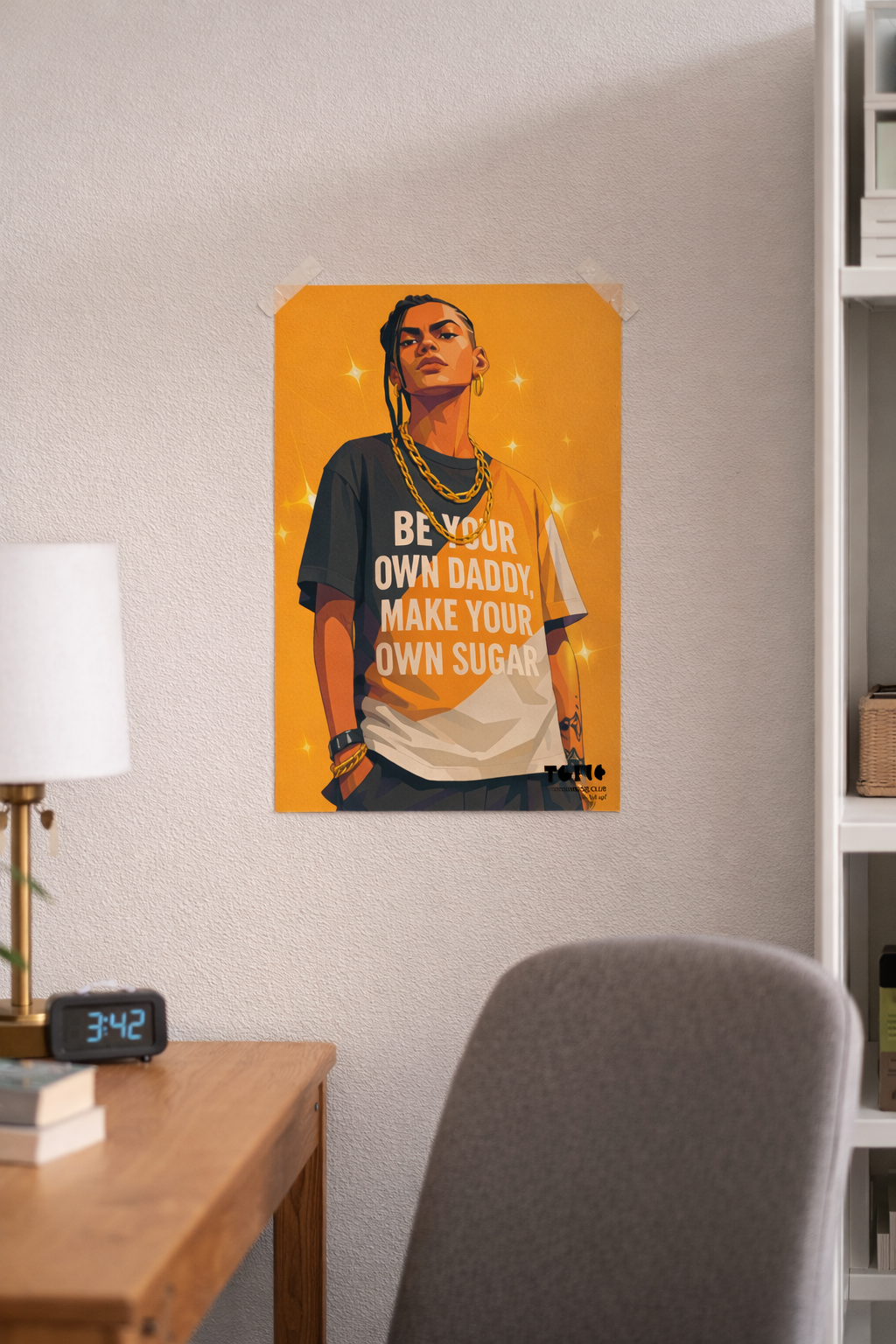 Poster of a person with text on an orange background in a room with a desk and lamp.