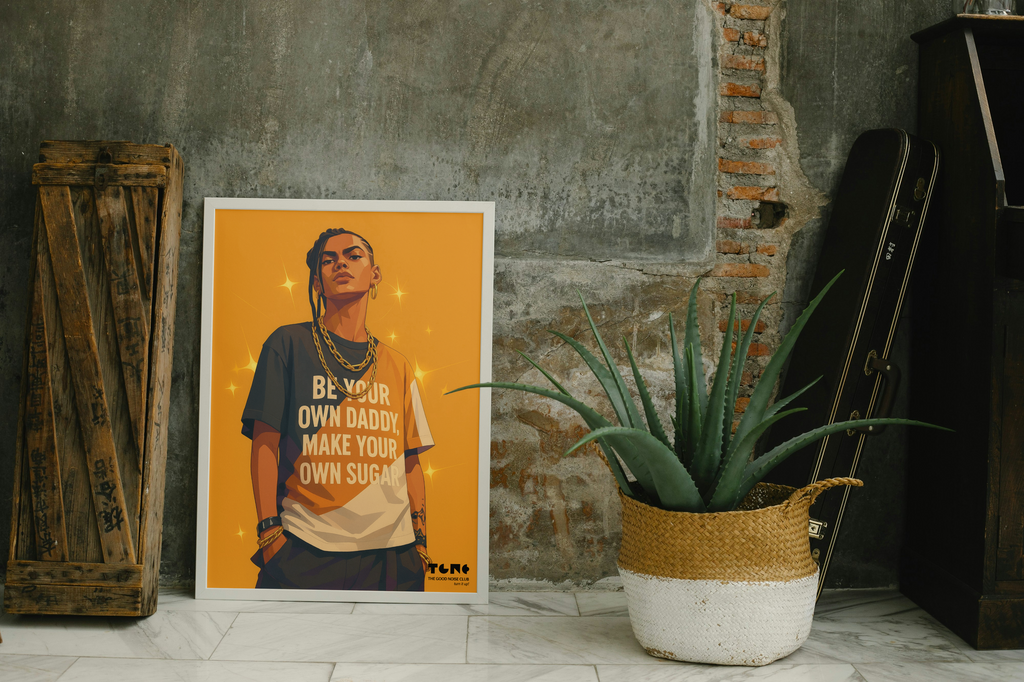 Poster of a person with text on an orange background, placed on a floor next to a plant and wooden crate.