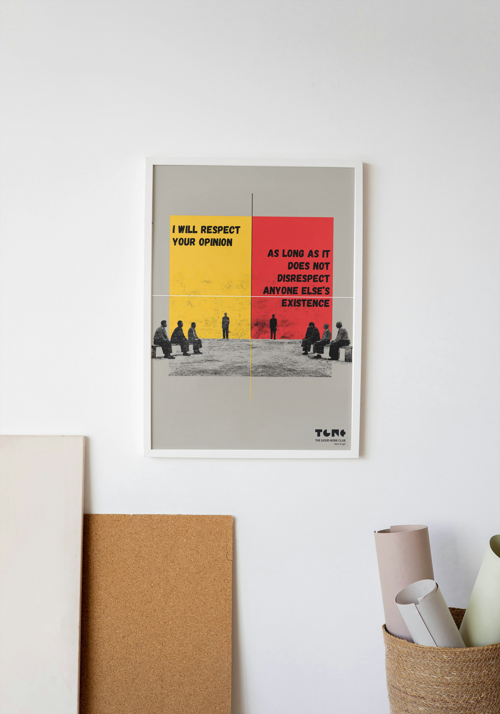 Framed poster with text and people on a white wall with decor items below.