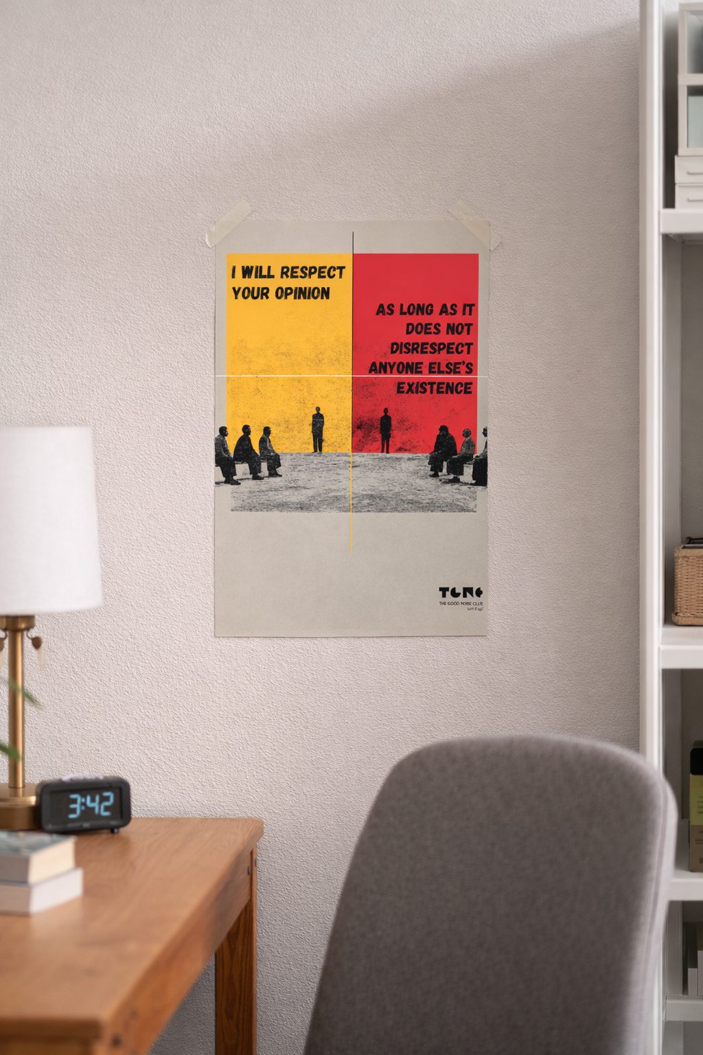 Poster with philosophical quote on a wall above a desk and chair.