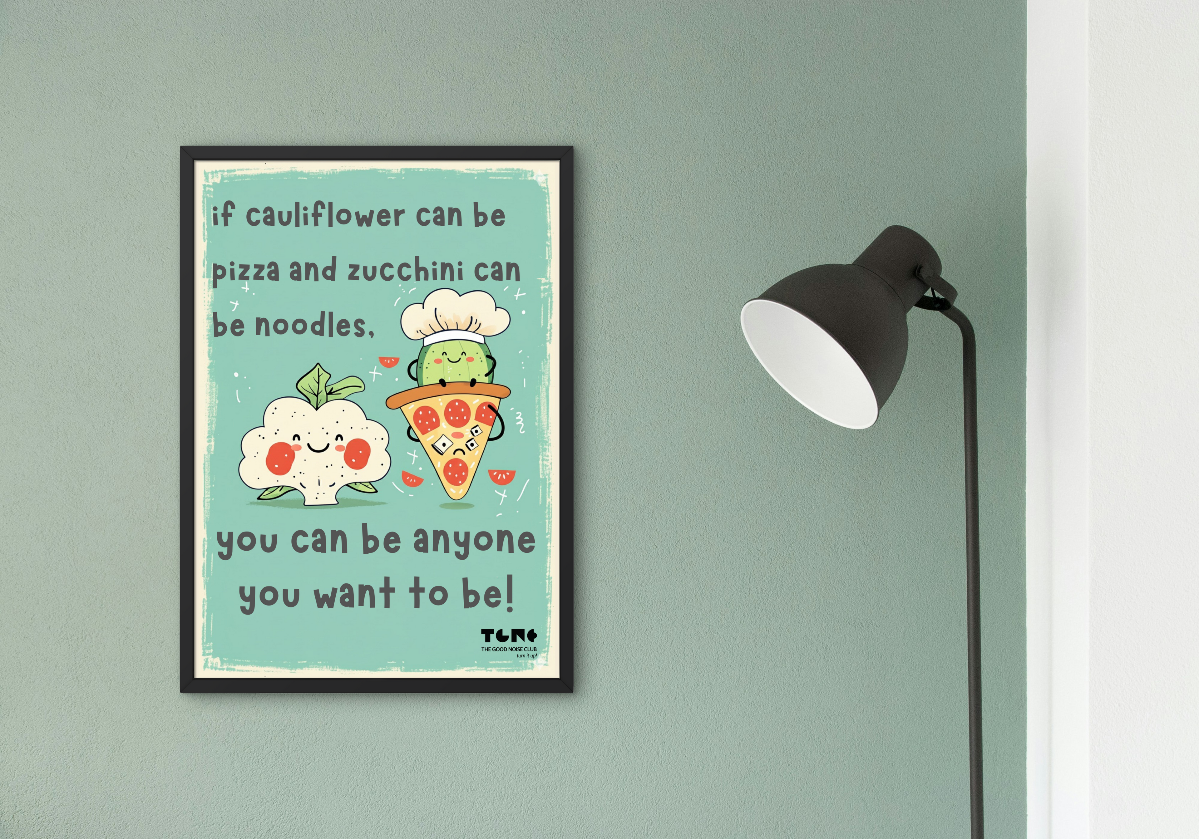 Framed poster with a motivational quote on a wall next to a lamp.
