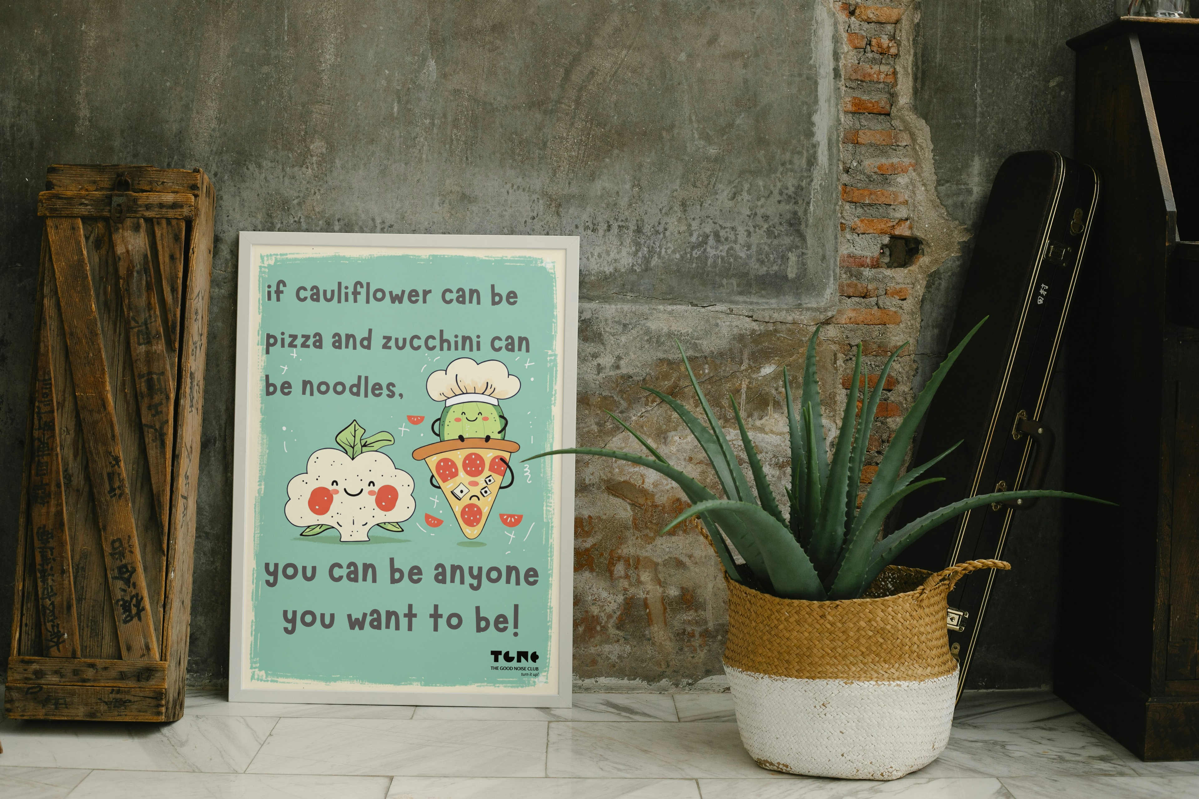 Motivational poster with a plant and wooden crate against a textured wall.