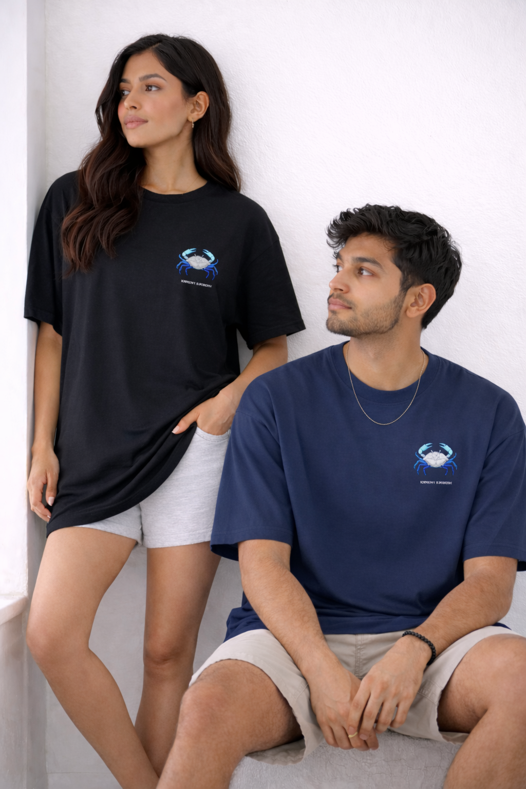Two people wearing black and blue t-shirts with a logo on a white background
