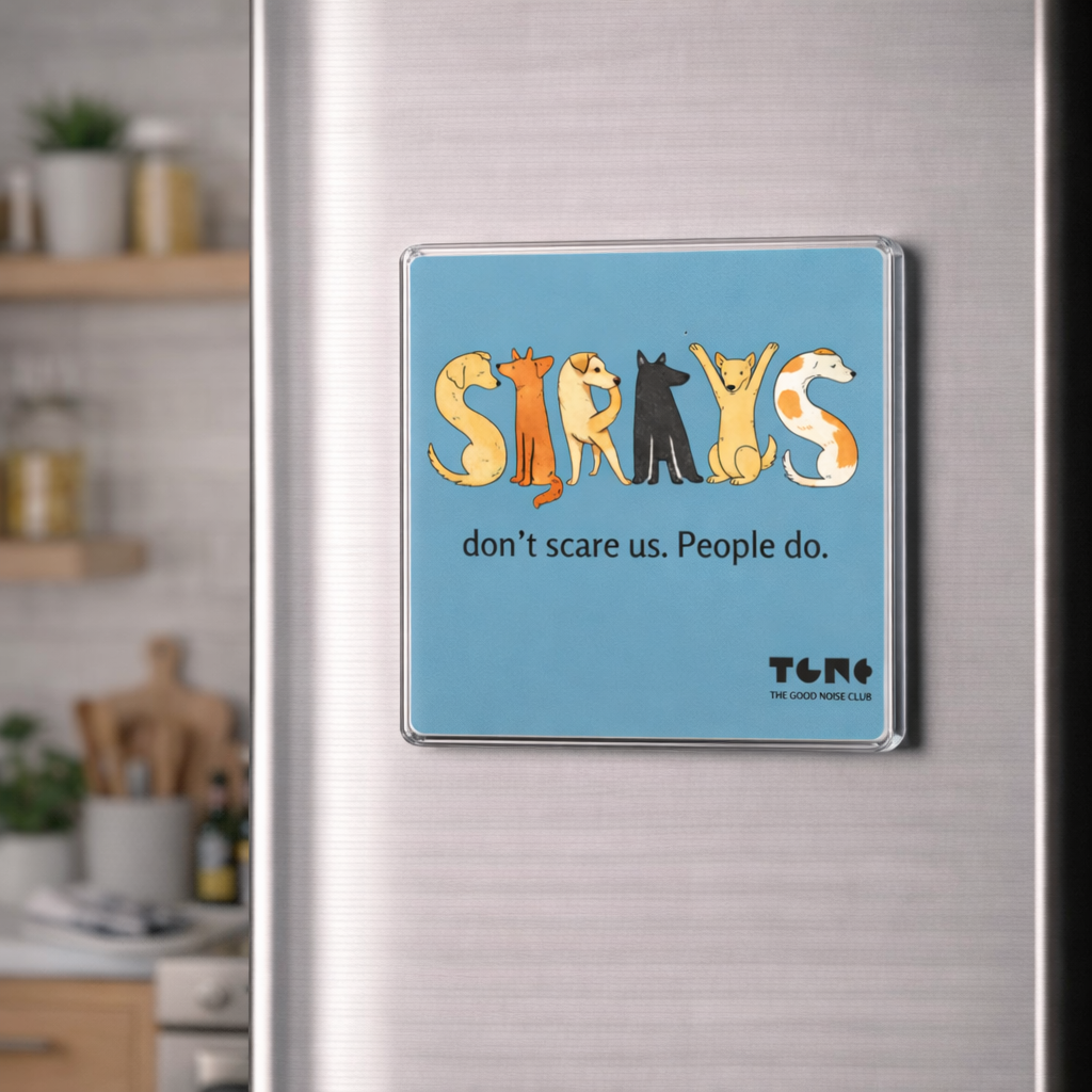 Fridge magnet with cartoon dogs and text on a metallic refrigerator