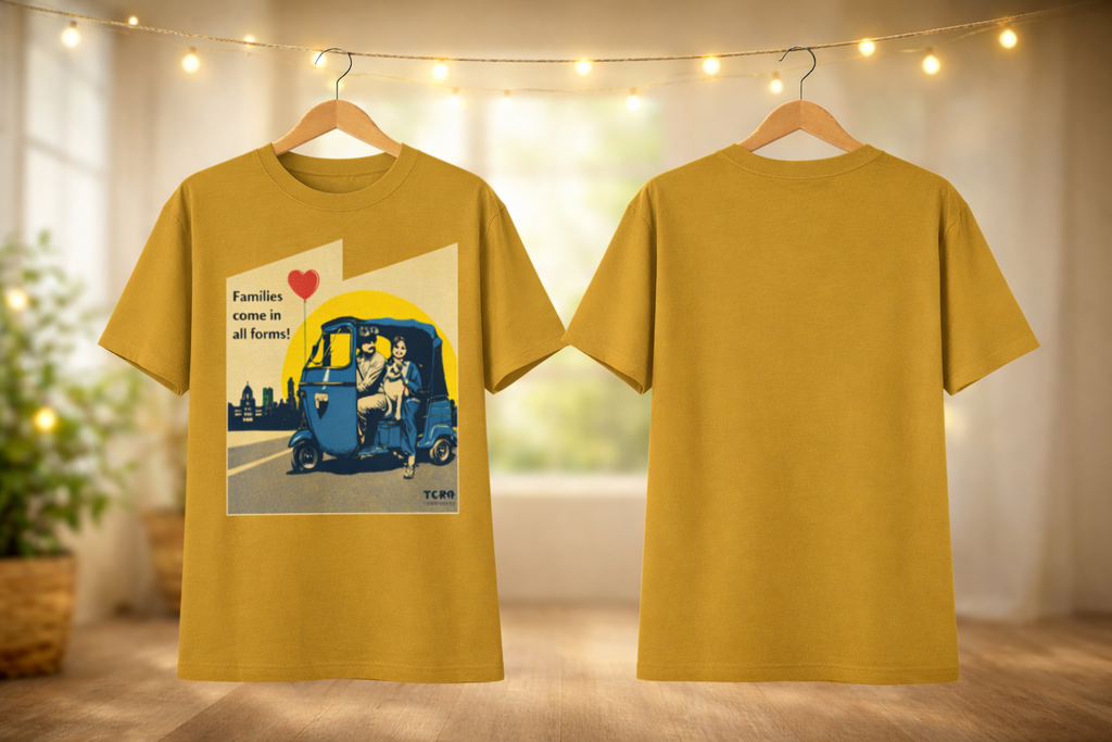 Yellow t-shirt with a graphic design of a family in an auto-rickshaw, hanging on a wooden hanger against a blurred indoor background.