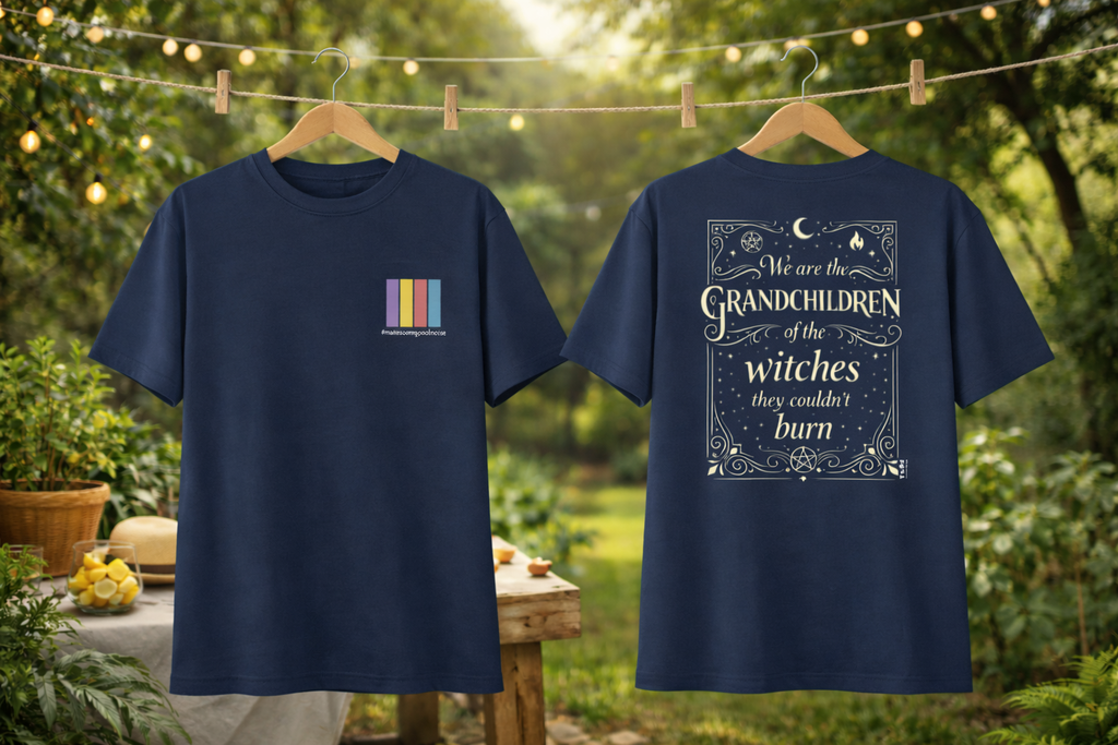Two navy blue t-shirts with text and graphics on hangers against a natural background.