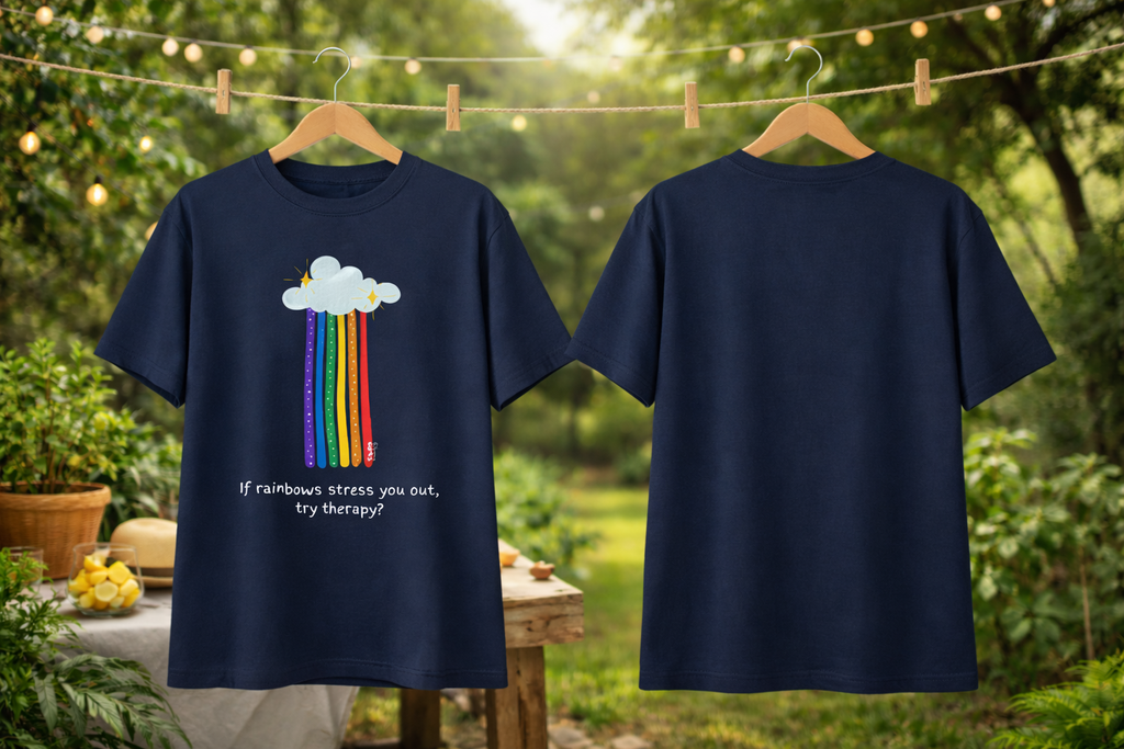 Navy blue t-shirt with rainbow and cloud design on a hanger against a natural background.