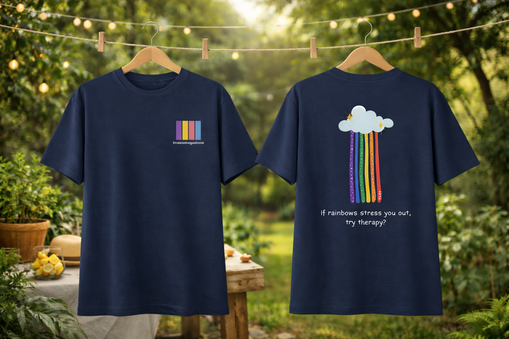 Two navy blue t-shirts with colorful designs on hangers against a natural background.