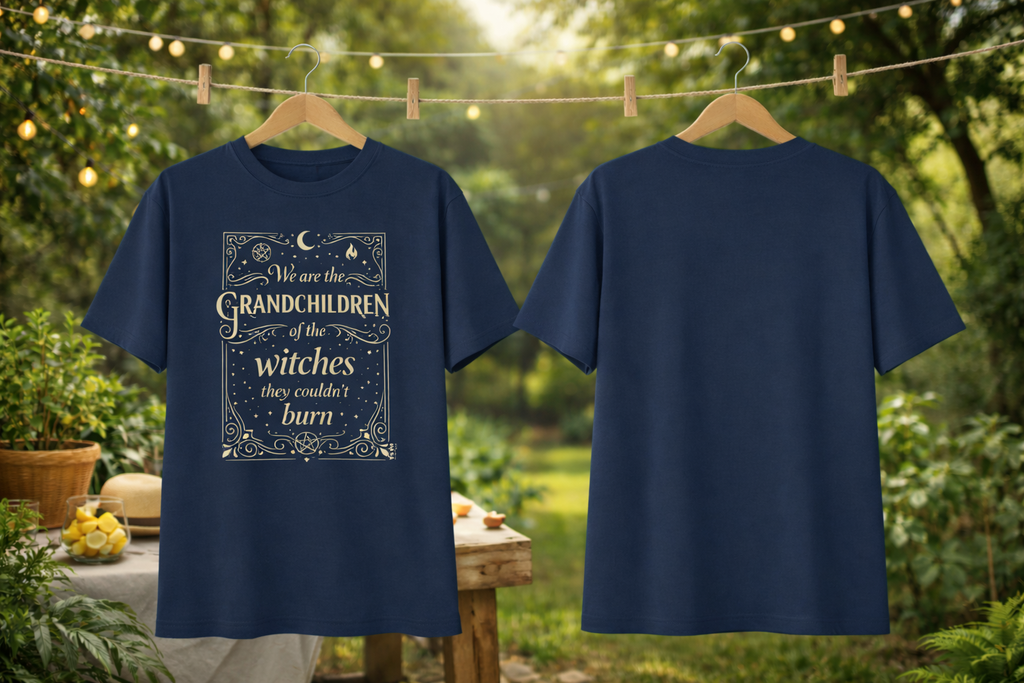 Navy blue t-shirt with a printed design on a wooden hanger against a garden background.