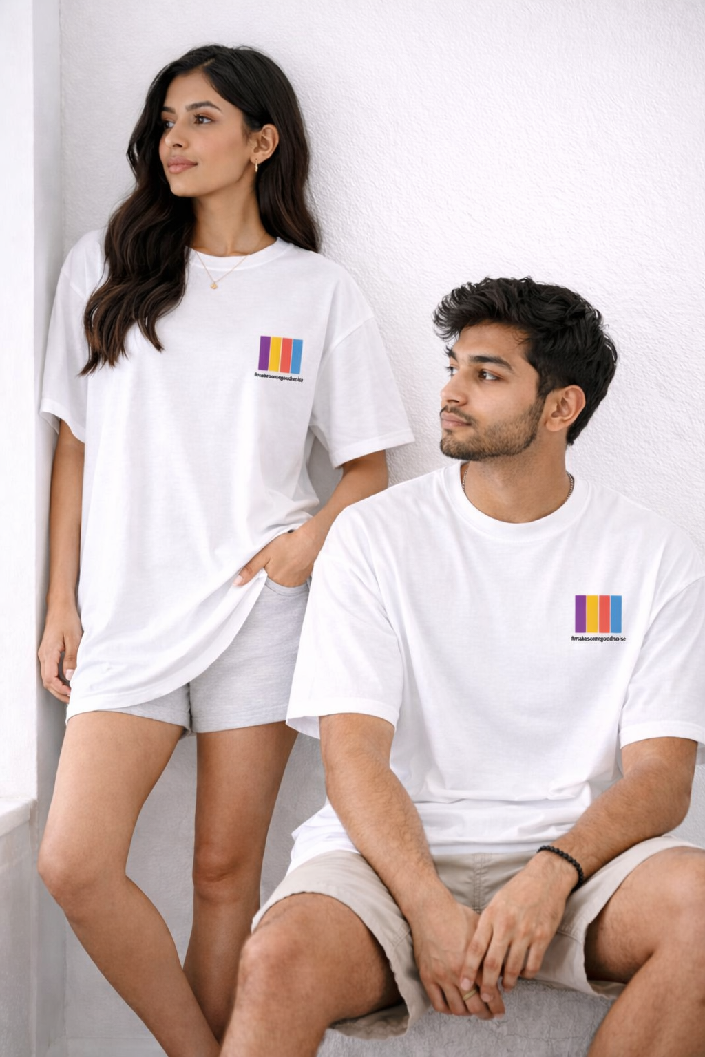 Two people wearing white t-shirts with a colorful logo on a light gray background