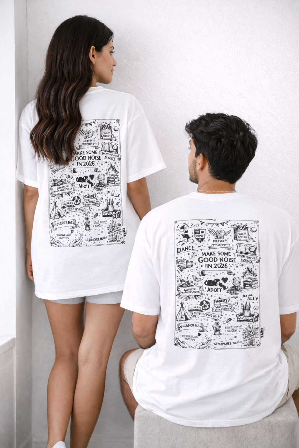 Two people wearing white t-shirts with black graphic designs on the back.