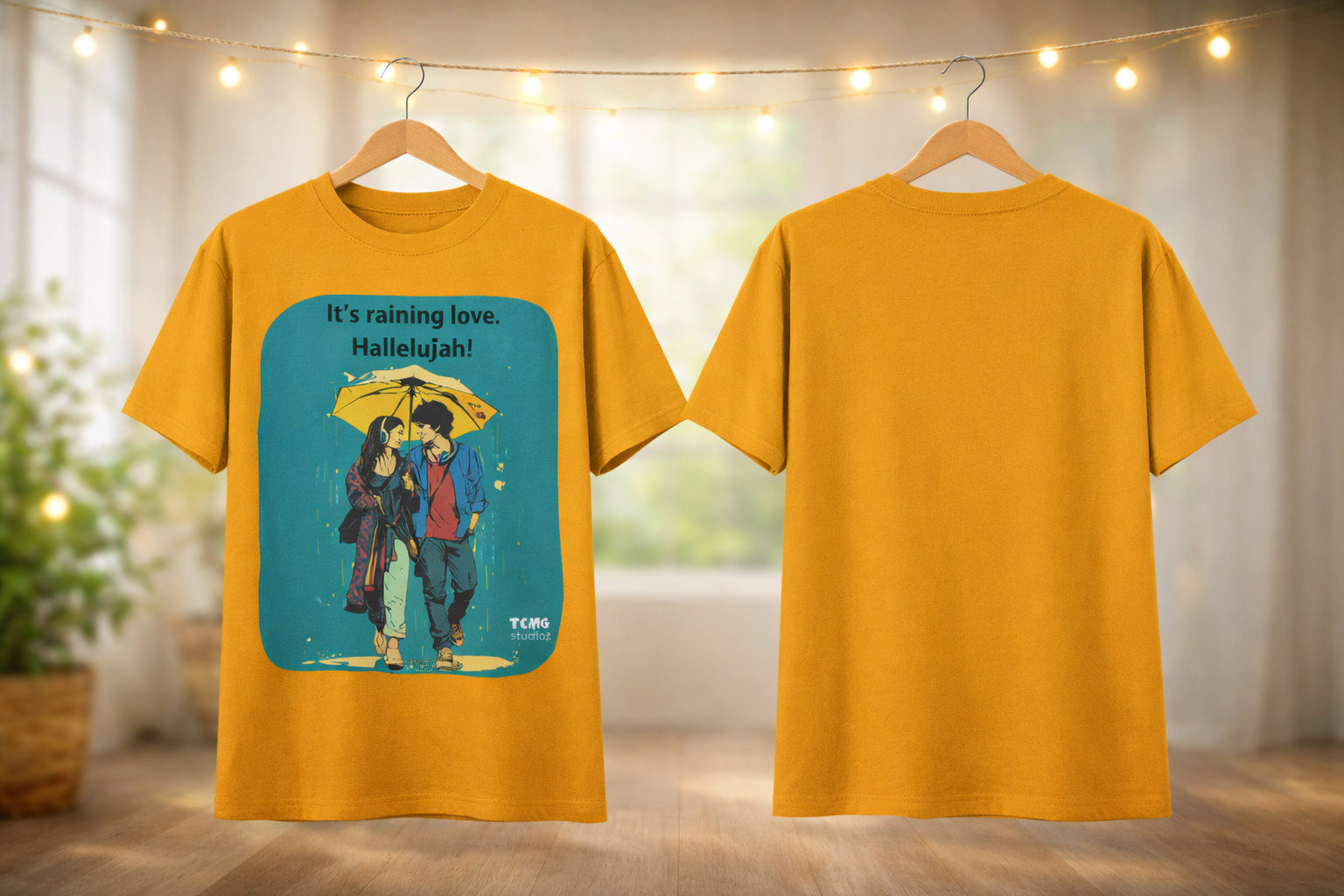 Yellow t-shirt with a graphic design of two people under an umbrella and text, displayed on hangers against a neutral background.