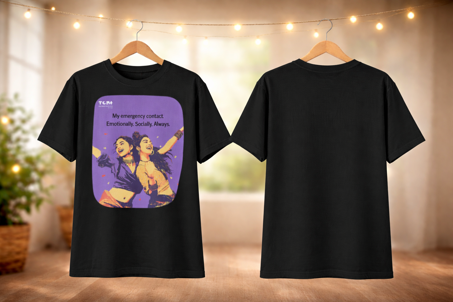 Black t-shirt with a graphic design on a hanger against a blurred indoor background.