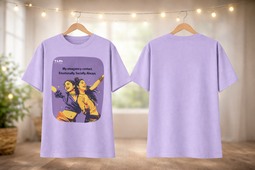 Purple t-shirt with graphic design and text on a wooden floor with lights in the background