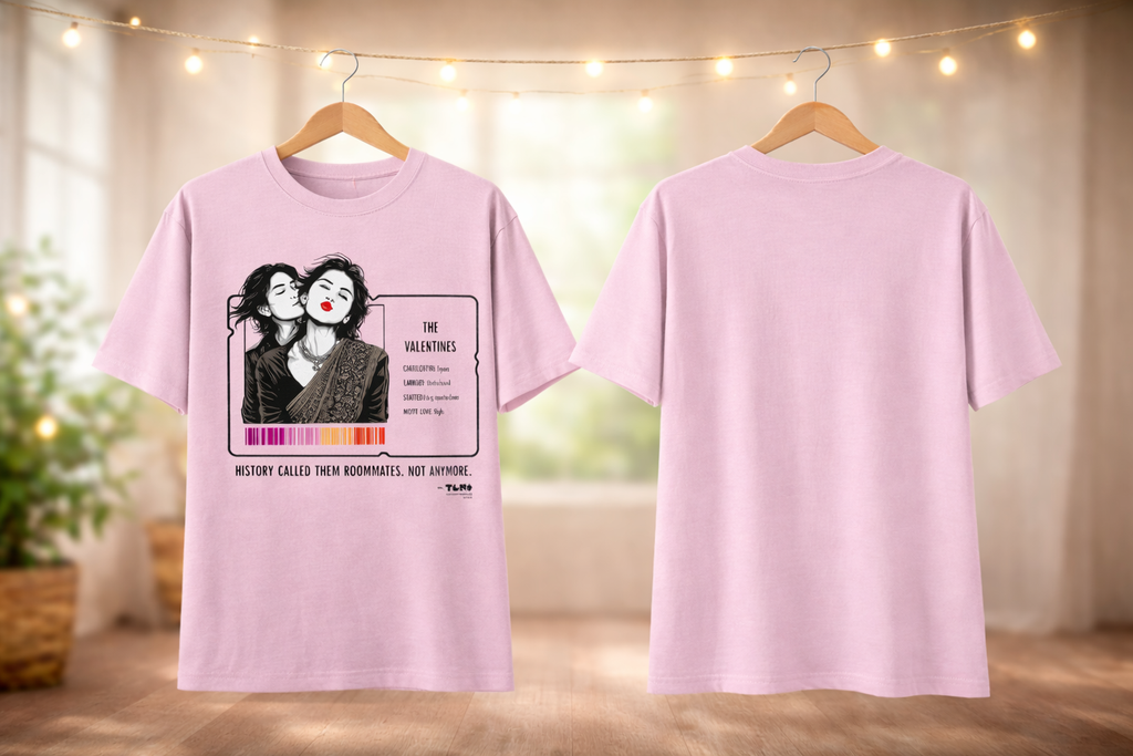 Pink t-shirt with graphic design on a hanger against a blurred indoor background