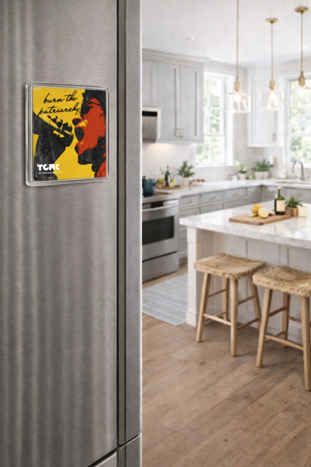 Kitchen with a refrigerator featuring a colorful poster and wooden stools on a light wood floor.
