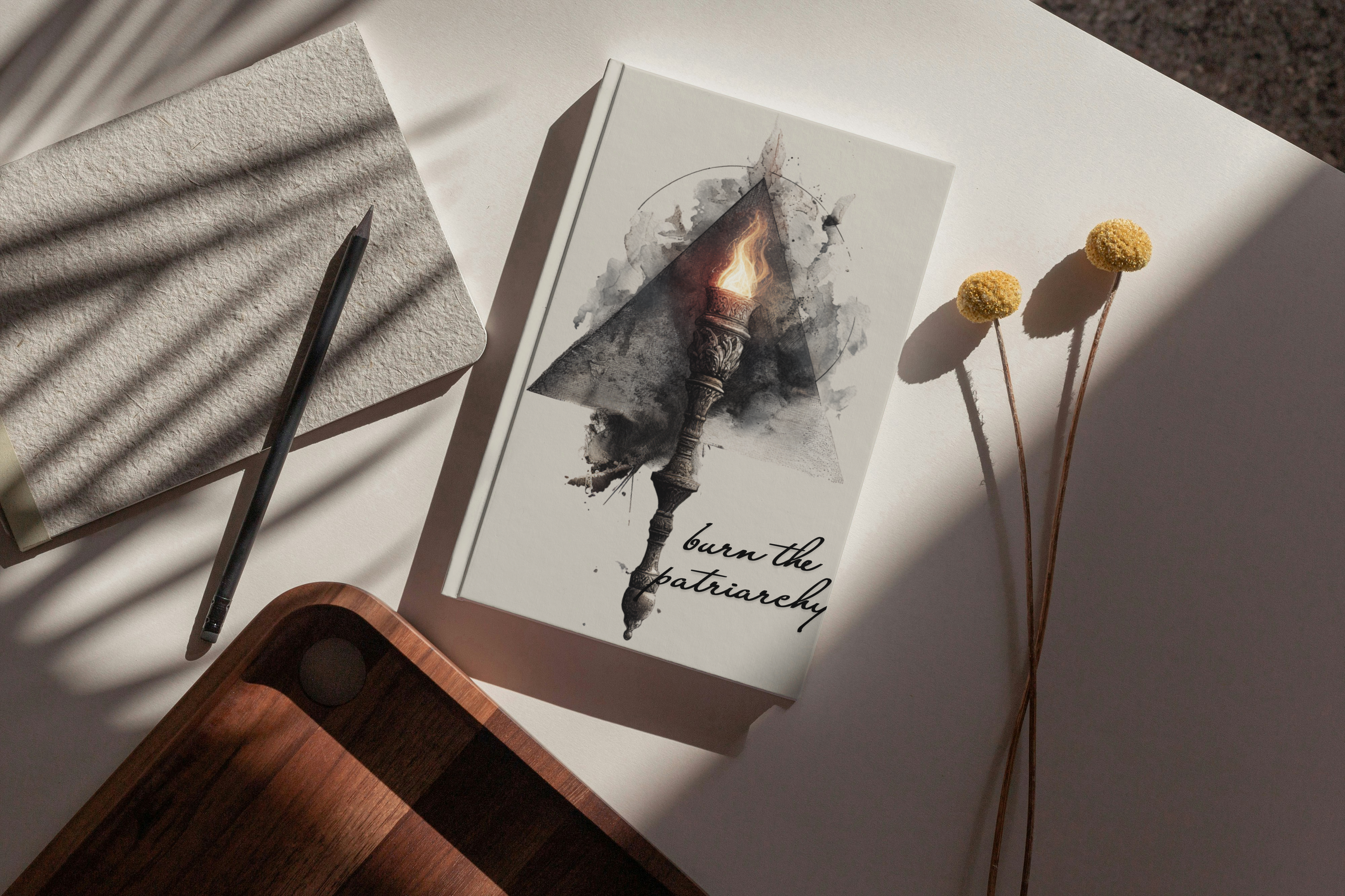 Notebook with a pen, card with a butterfly design, and dried flowers on a textured surface