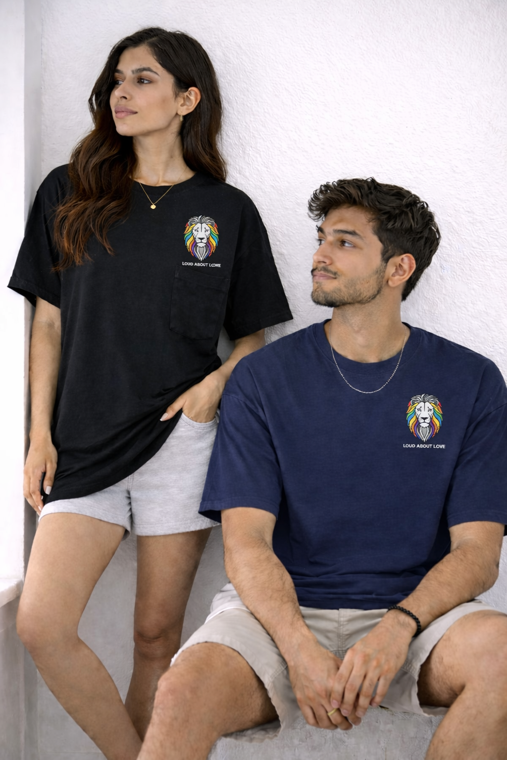 Two people wearing black and navy t-shirts with a logo on a white background