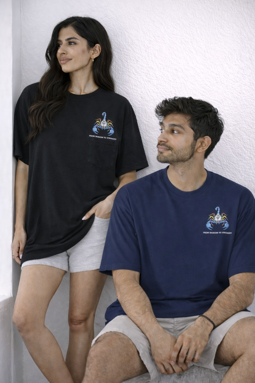 Two people wearing black and blue t-shirts with a logo on a white background